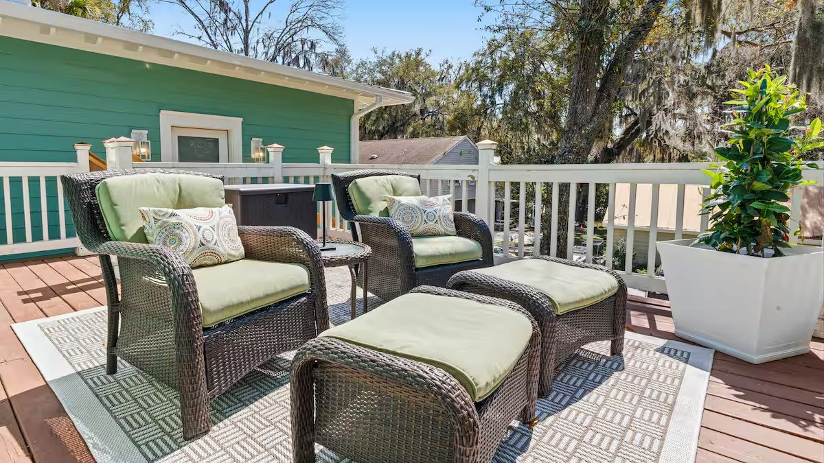 Private treetop deck with cushioned chairs overlooking Bootlegger Cove and Spanish moss-draped oaks