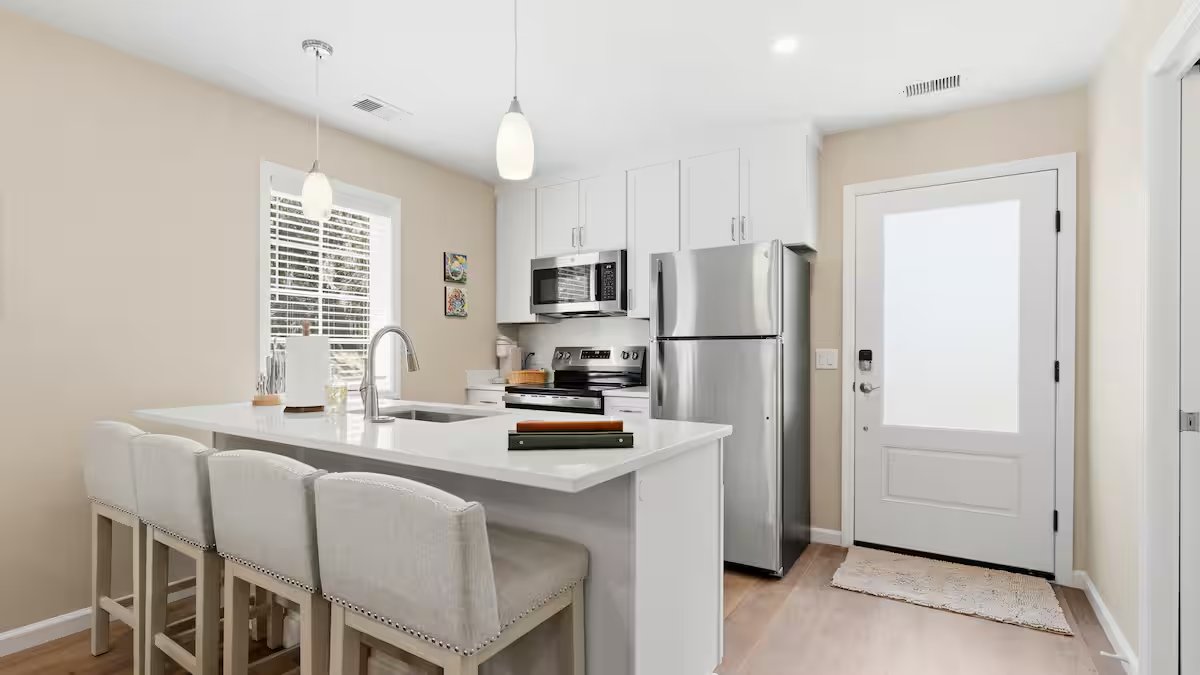 Full kitchen with quartz island, bar stools, and new stainless steel appliances